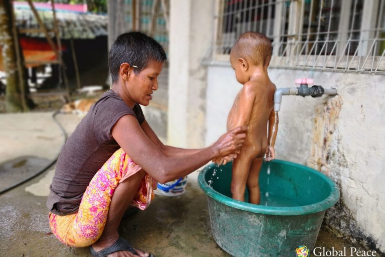 IMG_20180517_115431 (1)-min A grandmother bathing her grandson with filtered water. All the children in the village now bathe three times a day on average with clean water, reducing the occurrence of skin disease and fevers