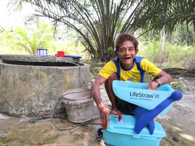 An orang asli washing the Lifestraw filter