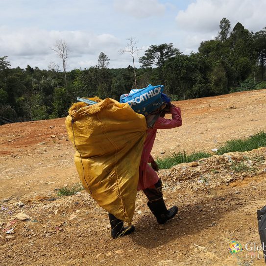 A scavenger bringing her finds to be sorted and packed.